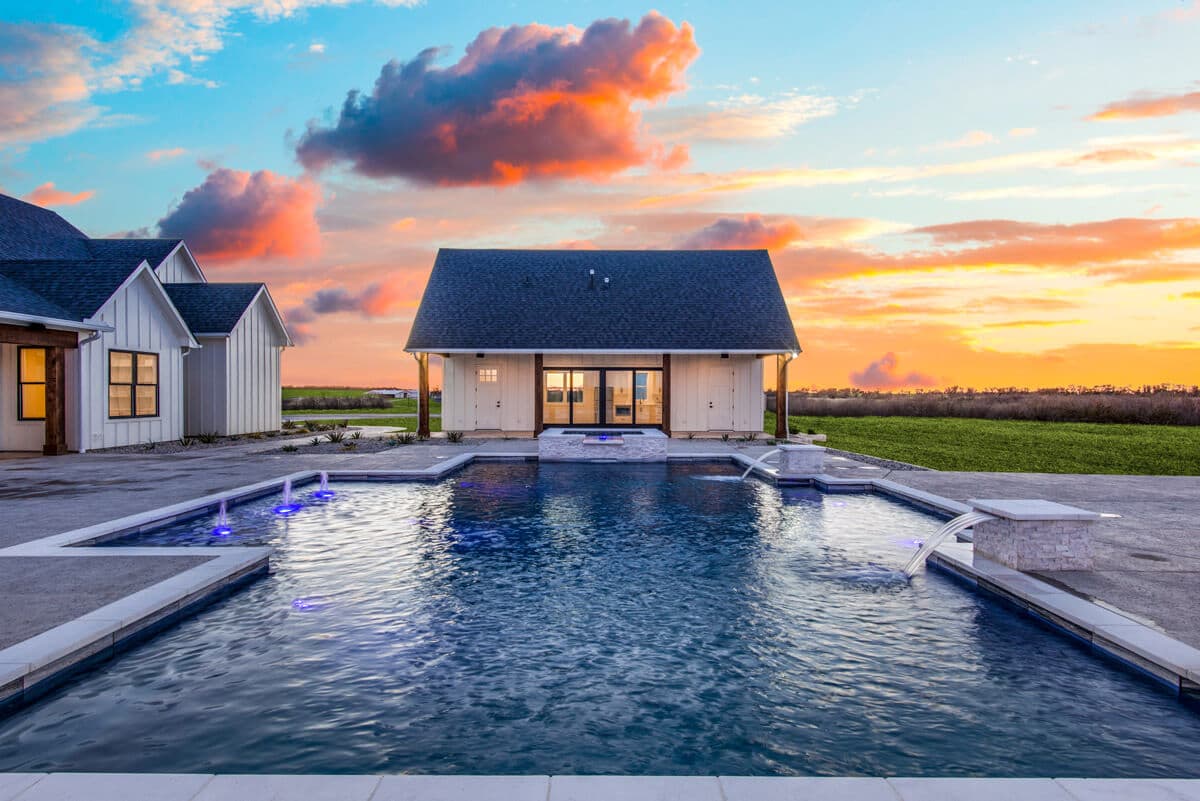 Custom pool and modern farmhouse at sunset — Tioga, TX — J C Boyd Custom Builders